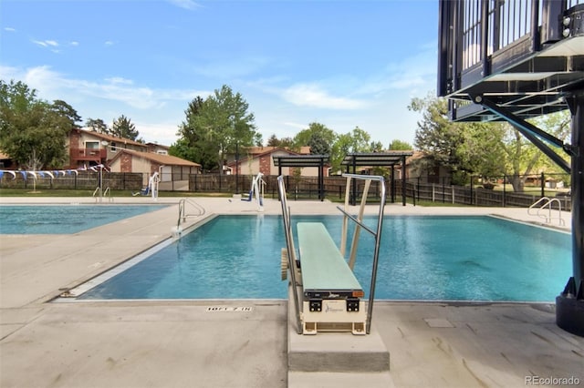 community pool featuring fence and a patio