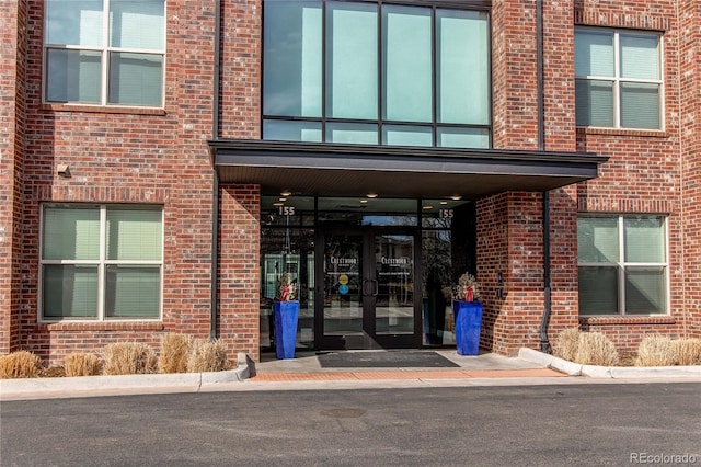 entrance to property featuring brick siding and french doors