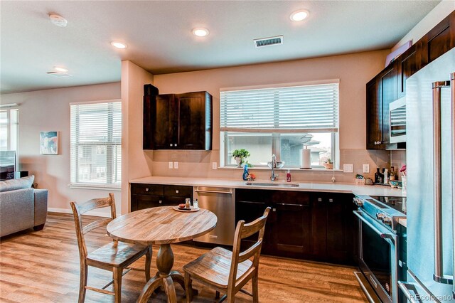 155 S Monaco Street Parkway Unit 311, Denver, CO 80224 - kitchen with stainless steel appliances, visible vents, backsplash, a sink, and light wood-type flooring