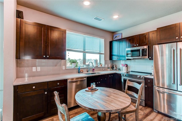 155 S Monaco Street Parkway Unit 311, Denver, CO 80224 - kitchen with dark brown cabinetry, visible vents, appliances with stainless steel finishes, a sink, and backsplash