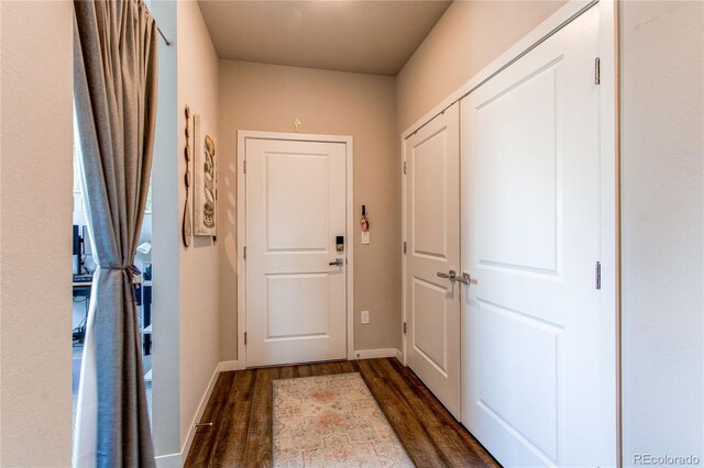 155 S Monaco Street Parkway Unit 311, Denver, CO 80224 - doorway to outside with dark wood-style floors and baseboards
