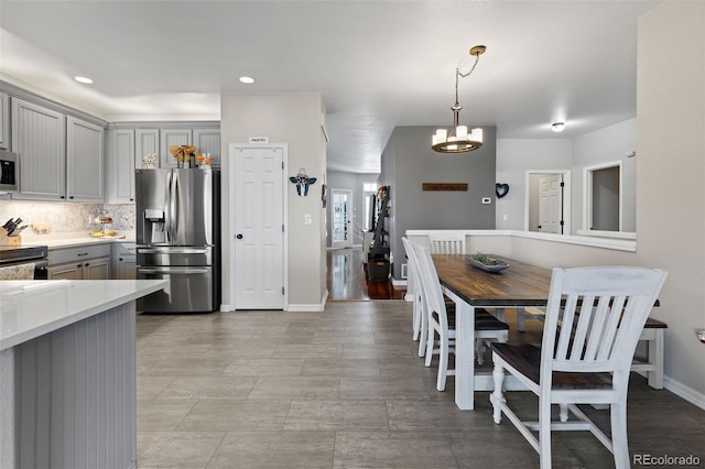 5611 S Sicily Cir, Aurora, CO 80015 - kitchen with baseboards, light countertops, a notable chandelier, gray cabinetry, and stainless steel appliances
