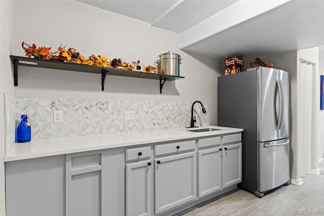 5611 S Sicily Cir, Aurora, CO 80015 - kitchen with open shelves, a sink, freestanding refrigerator, backsplash, and gray cabinetry