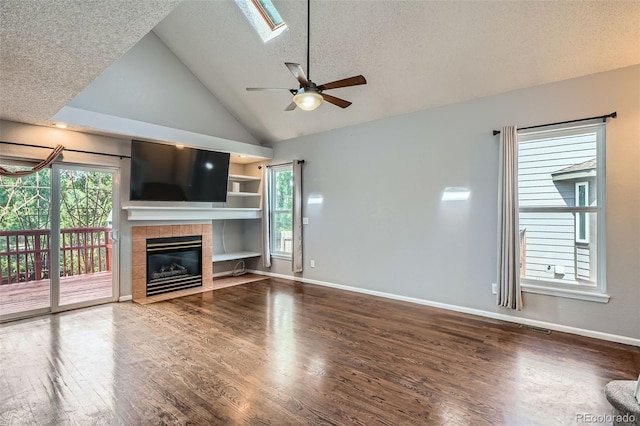 13155 W 63rd Pl, Arvada, CO 80004 - unfurnished living room with wood finished floors, a ceiling fan, a fireplace, a textured ceiling, and high vaulted ceiling