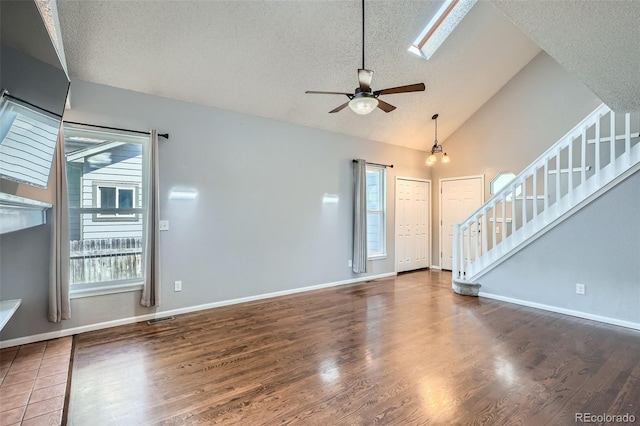 13155 W 63rd Pl, Arvada, CO 80004 - unfurnished living room featuring a textured ceiling, a ceiling fan, wood finished floors, stairs, and high vaulted ceiling