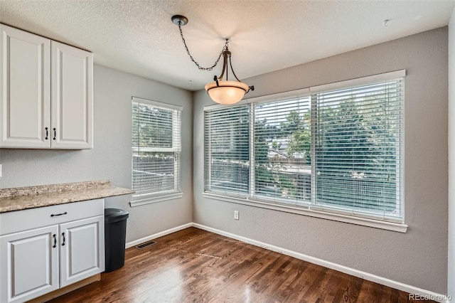 13155 W 63rd Pl, Arvada, CO 80004 - unfurnished dining area with dark wood-type flooring and baseboards