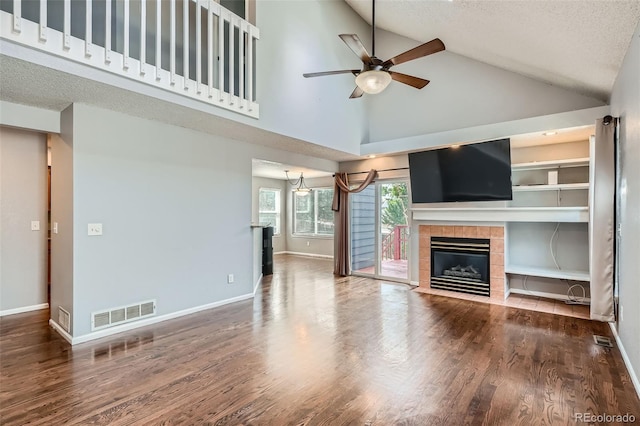 13155 W 63rd Pl, Arvada, CO 80004 - unfurnished living room featuring a fireplace, a ceiling fan, high vaulted ceiling, wood finished floors, and a textured ceiling