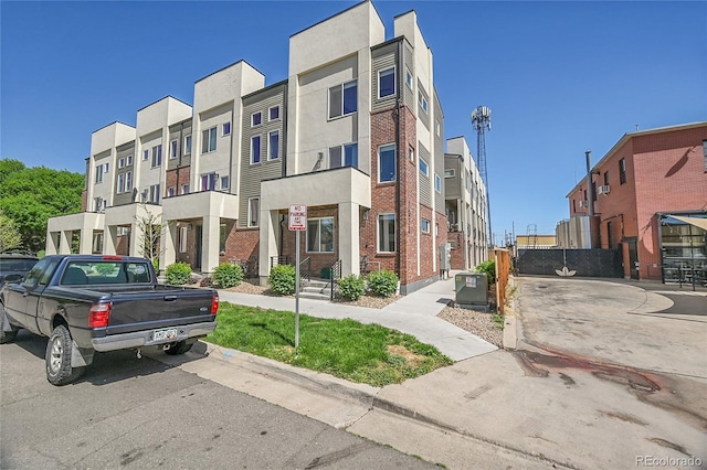 7035 E 38th Ave Unit 4, Denver, CO 80207 - view of front of house with central AC unit, stucco siding, and brick siding