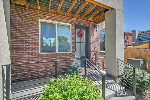 7035 E 38th Ave Unit 4, Denver, CO 80207 - doorway to property with brick siding, stucco siding, and fence
