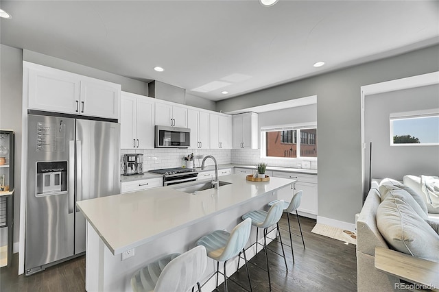 7035 E 38th Ave Unit 4, Denver, CO 80207 - kitchen featuring appliances with stainless steel finishes, a sink, decorative backsplash, healthy amount of natural light, and recessed lighting