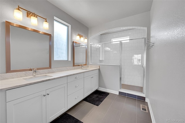 6632 Osage St, Denver, CO 80221 - bathroom featuring baseboards, double vanity, a stall shower, and tile patterned floors