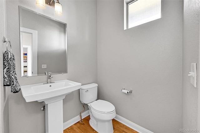6632 Osage St, Denver, CO 80221 - bathroom featuring wood finished floors, toilet, and baseboards