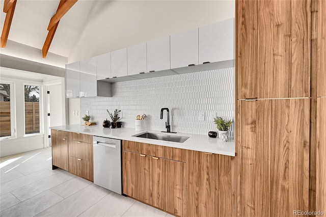 kitchen featuring backsplash, dishwasher, light countertops, modern cabinets, and a sink