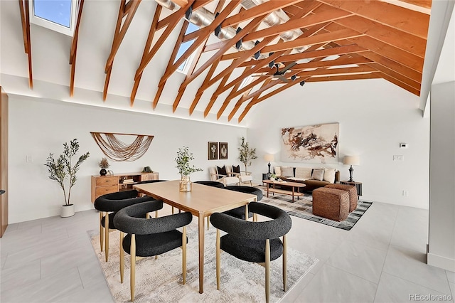 dining area with light tile patterned floors and high vaulted ceiling