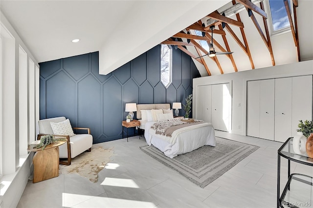 bedroom featuring a decorative wall, two closets, and lofted ceiling