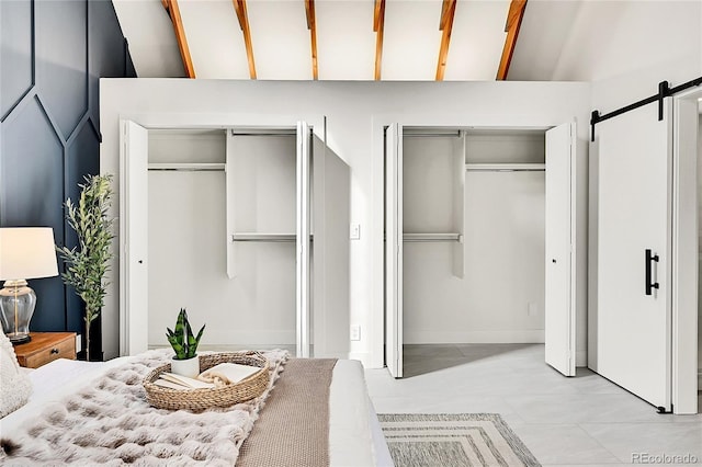 bedroom featuring a barn door and multiple closets