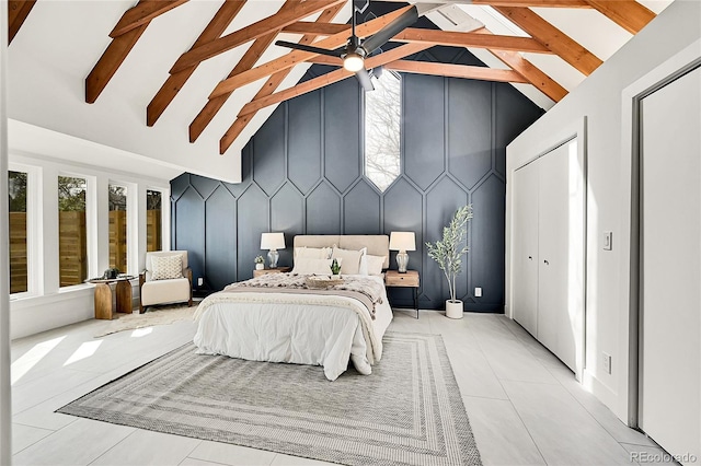 bedroom with a decorative wall, light tile patterned floors, beamed ceiling, and high vaulted ceiling