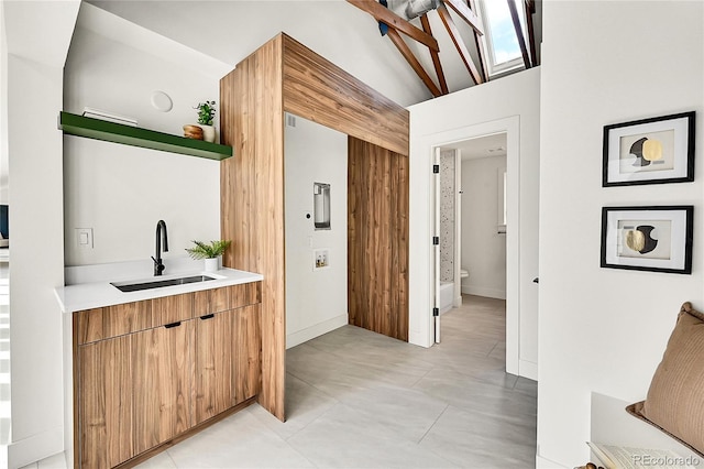 bar featuring lofted ceiling and a sink