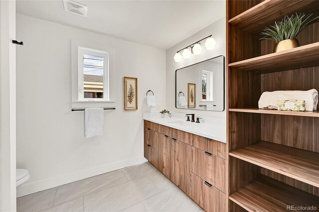 bathroom featuring visible vents, toilet, tile patterned flooring, baseboards, and vanity