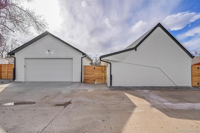 detached garage featuring fence and a gate