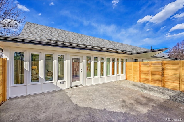 back of house featuring a patio, fence, and a shingled roof