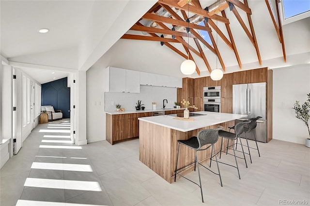 kitchen with brown cabinets, appliances with stainless steel finishes, modern cabinets, and a sink