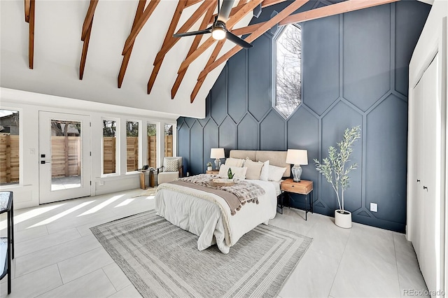 tiled bedroom with beamed ceiling, multiple windows, access to outside, and a decorative wall