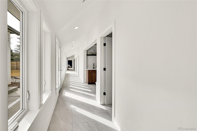hall featuring light tile patterned floors and recessed lighting