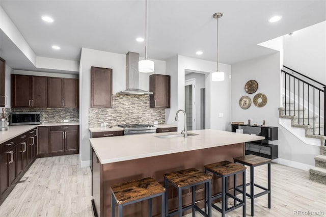 6018 Beeler Ct, Denver, CO 80238 - kitchen featuring wall chimney exhaust hood, a sink, stainless steel appliances, light wood-style floors, and backsplash
