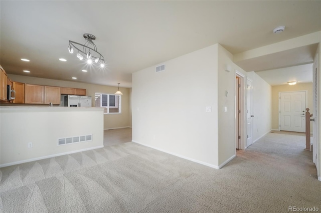 unfurnished living room with recessed lighting, baseboards, visible vents, and light colored carpet