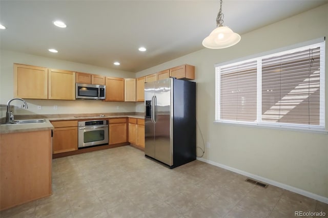 kitchen with stainless steel appliances, light brown cabinetry, a sink, and visible vents