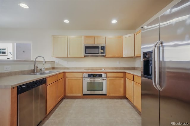 kitchen featuring a peninsula, light countertops, stainless steel appliances, a sink, and recessed lighting