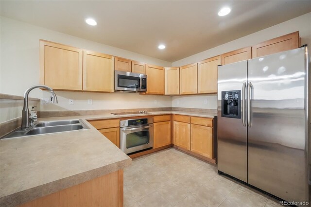 kitchen featuring stainless steel appliances, recessed lighting, light countertops, light brown cabinets, and a sink