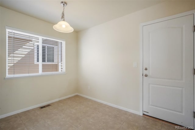 unfurnished room with baseboards and visible vents