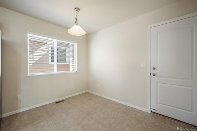 unfurnished room with visible vents and baseboards