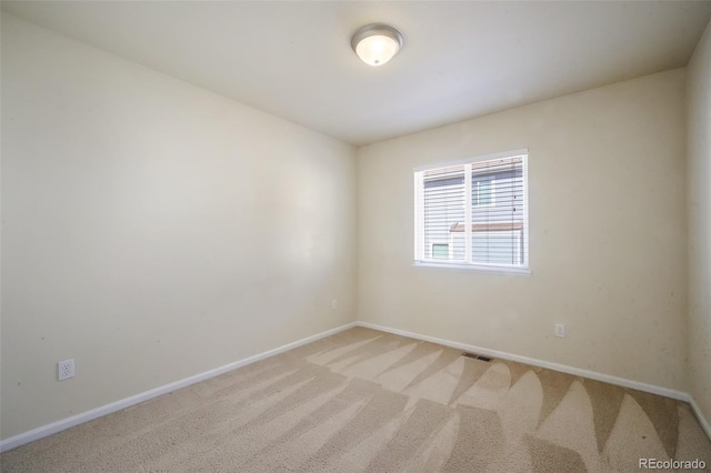 unfurnished room with baseboards, visible vents, and light colored carpet