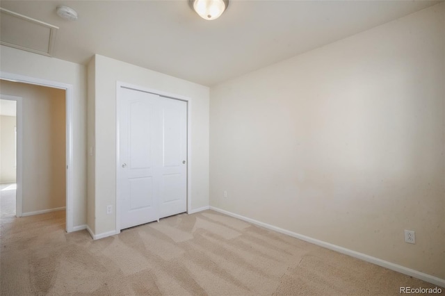 unfurnished bedroom with a closet, carpet, and baseboards