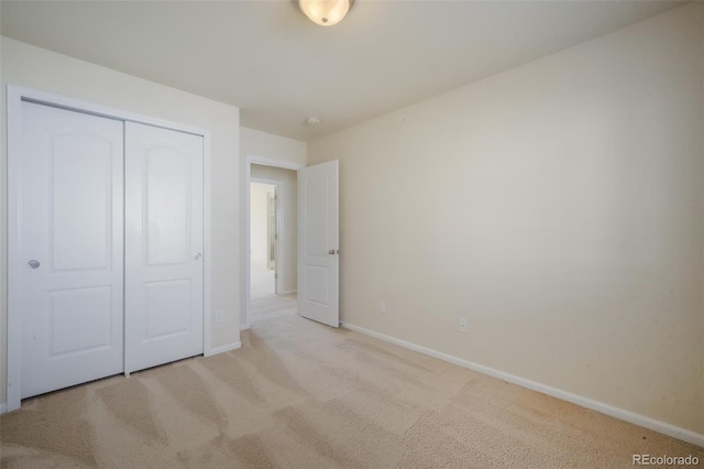 unfurnished bedroom with a closet, baseboards, and carpet flooring