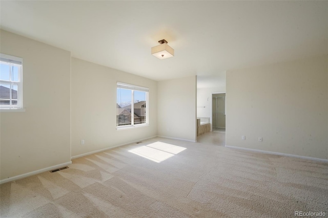 empty room featuring carpet, visible vents, and baseboards