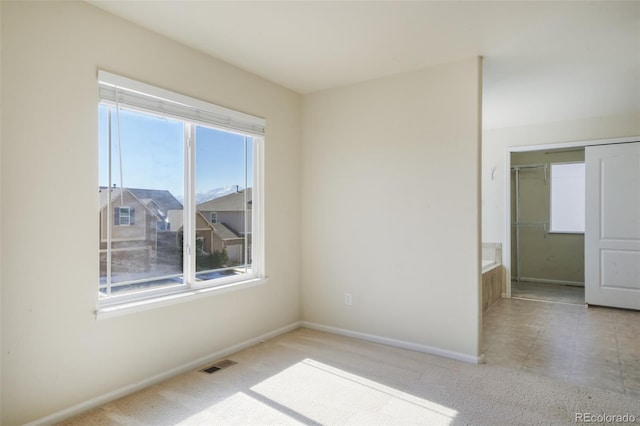 empty room featuring carpet floors, baseboards, and visible vents