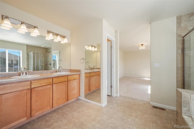 bathroom with a stall shower, visible vents, a sink, and double vanity