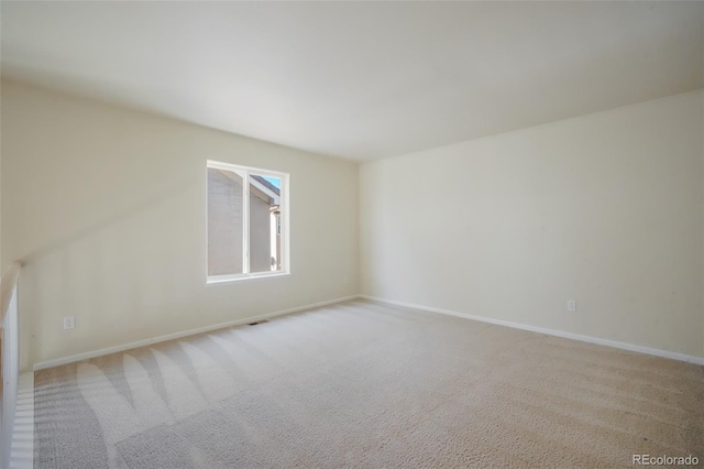 carpeted empty room with baseboards