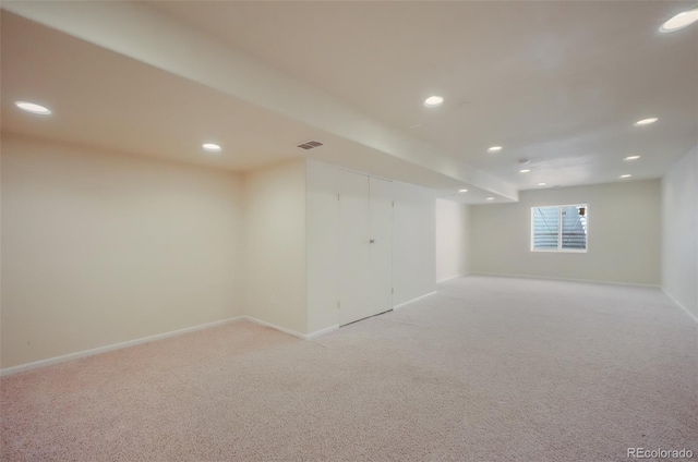 below grade area with light carpet, baseboards, visible vents, and recessed lighting