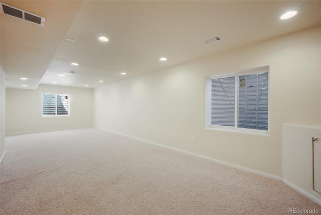 carpeted empty room featuring recessed lighting, visible vents, and baseboards