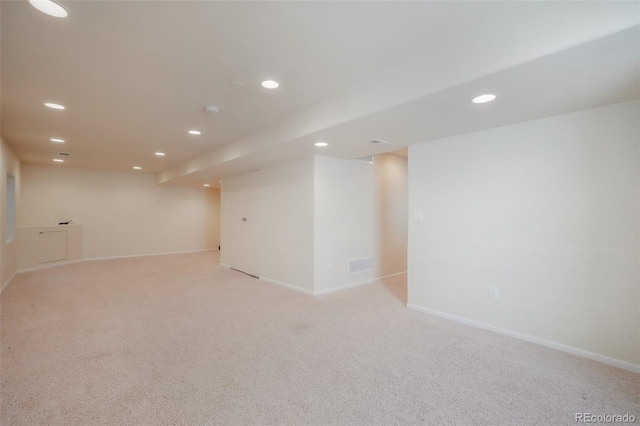 spare room featuring light carpet, visible vents, and recessed lighting