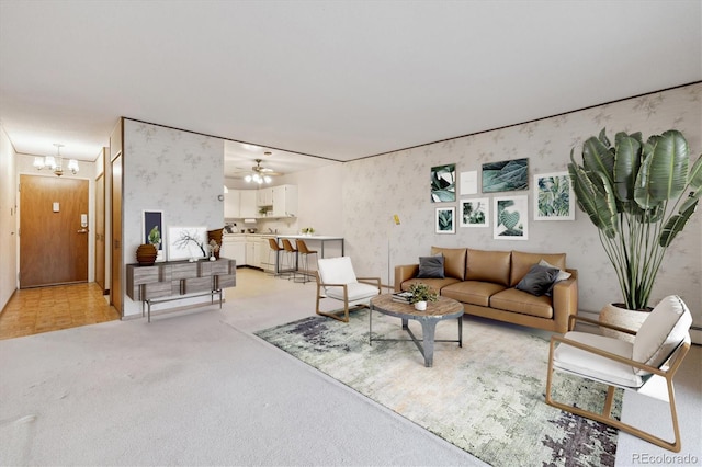 carpeted living room featuring ceiling fan with notable chandelier