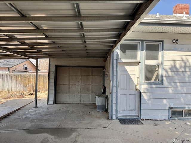 garage with a carport and fence