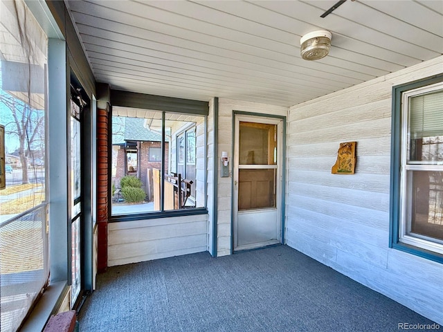 unfurnished sunroom featuring wooden ceiling and a healthy amount of sunlight