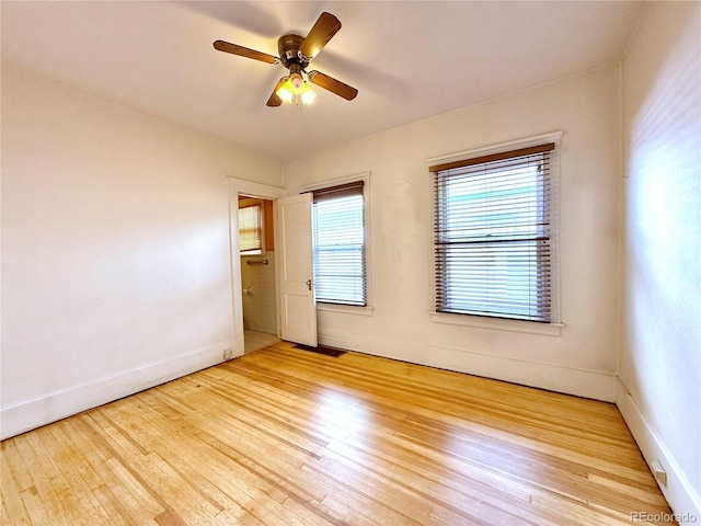 unfurnished room with a ceiling fan, light wood-style flooring, visible vents, and baseboards