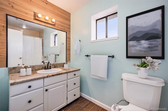 4681 S Decatur St Unit 327, Englewood, CO 80110 - bathroom with vanity, toilet, wood finished floors, and baseboards